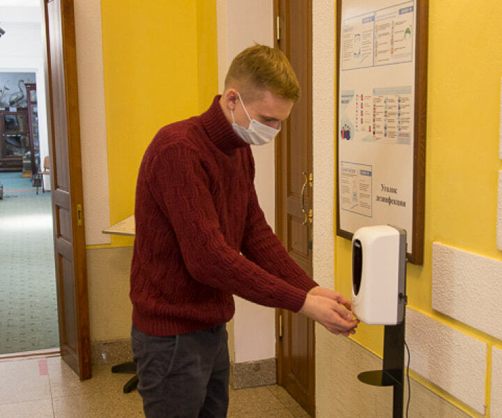 Посетитель музея обрабатывает руки антисептиком