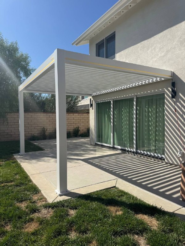 Wall-mounted aluminum patio cover above sliding doors in Huntington Beach