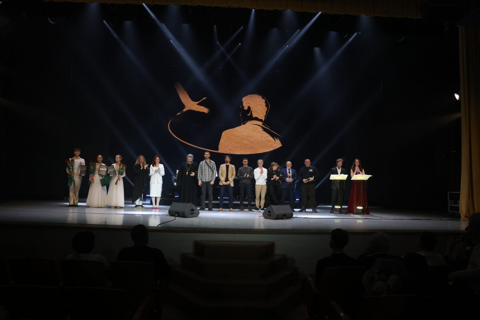 на фото люди на сцене в центре стоят лауреаты премии 