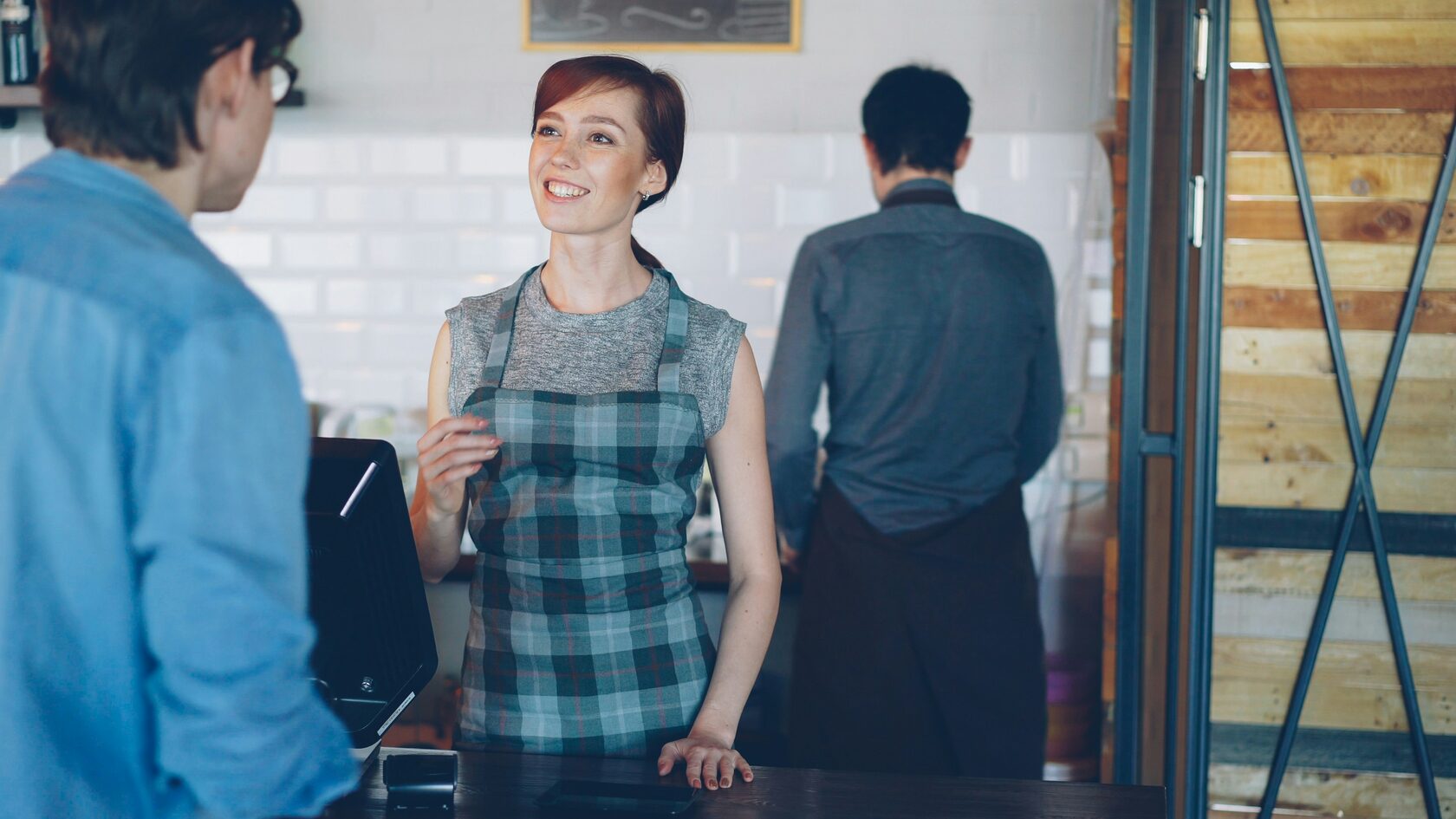 Restaurant owner greeting guests at the door in the evening
