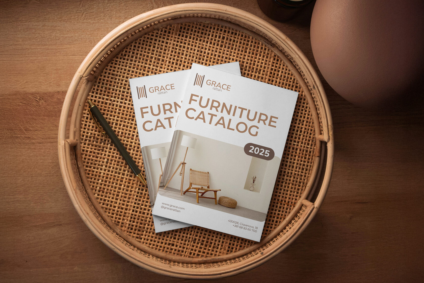 Furniture catalog designed by Leragraphics, displayed on a woven rattan tray with a pen on a wooden surface.