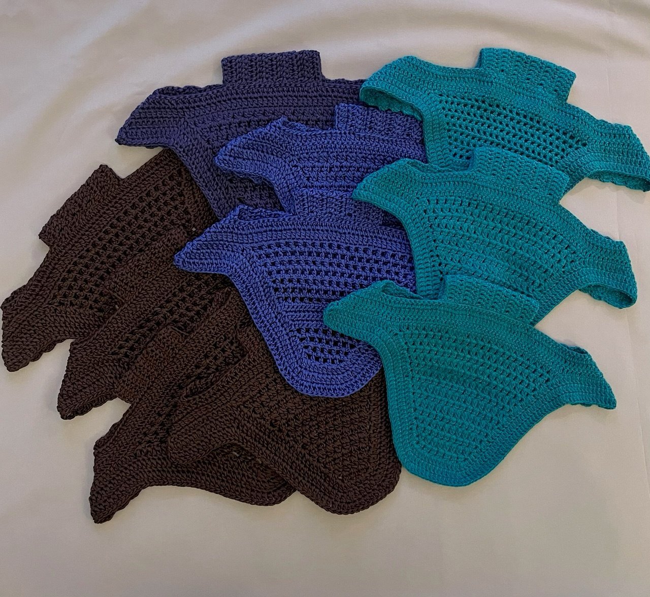 Knitted ear bonnet blanks in chocolate brown, blue and teal.