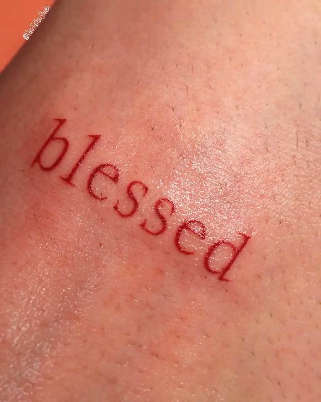 Красная тату-надпись blessed