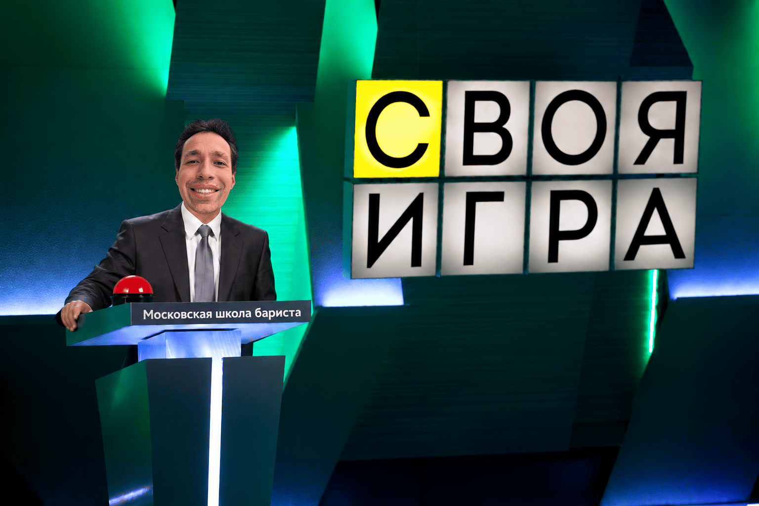 Ведущий за игровым пультом и экран «Своя игра»