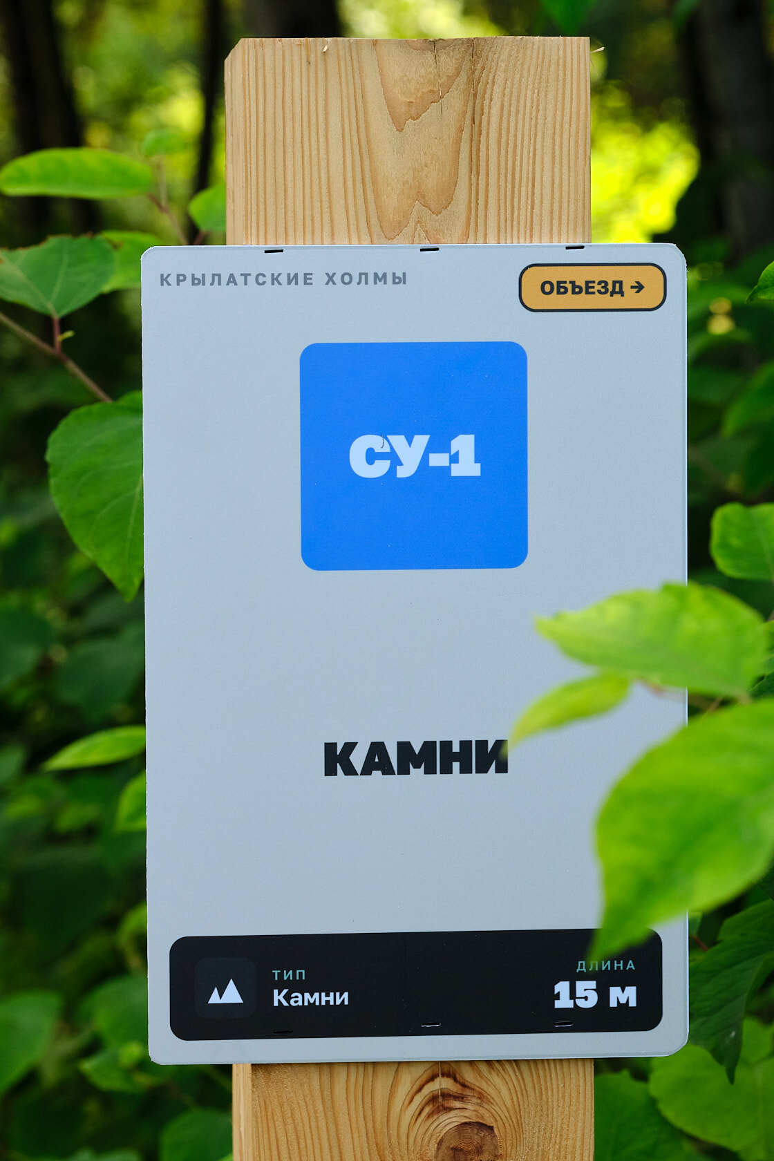Информационная табличка секции СУ-1 «Камни» на деревянном столбе трассы в Крылатском