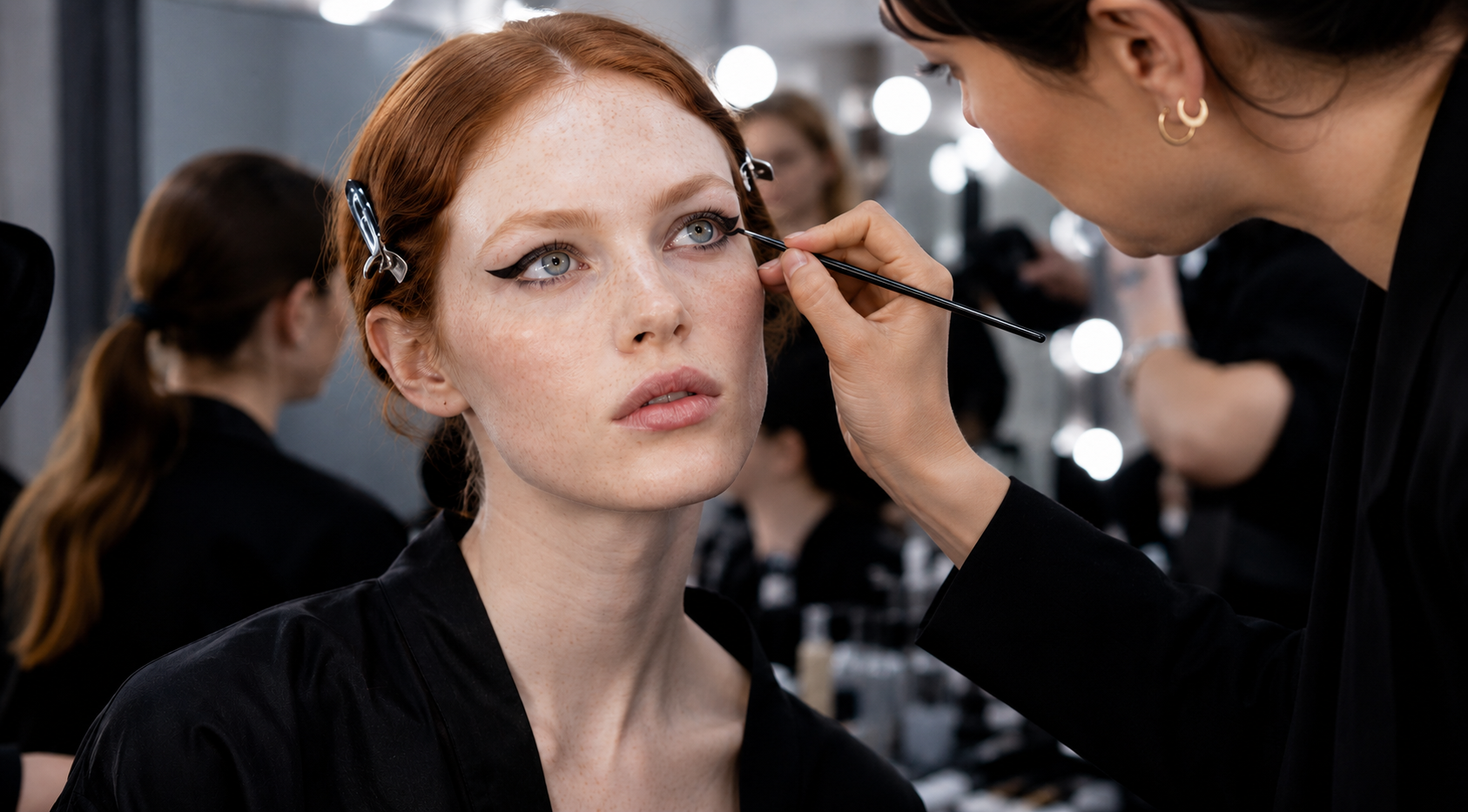Команда визажистов и стилистов готовит модель к выходу на подиум перед fashion-показом
