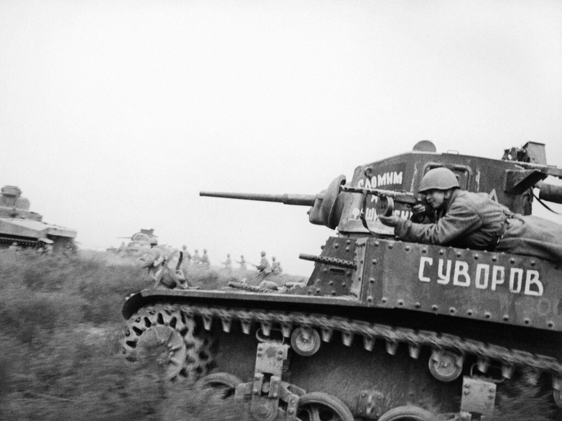 Пехотинец прицеливается из пистолета-пулемета, лежа на броне советского танка американского производства М3 «Стюарт». Донской фронт. Сталинградская область. Ноябрь 1942 г.