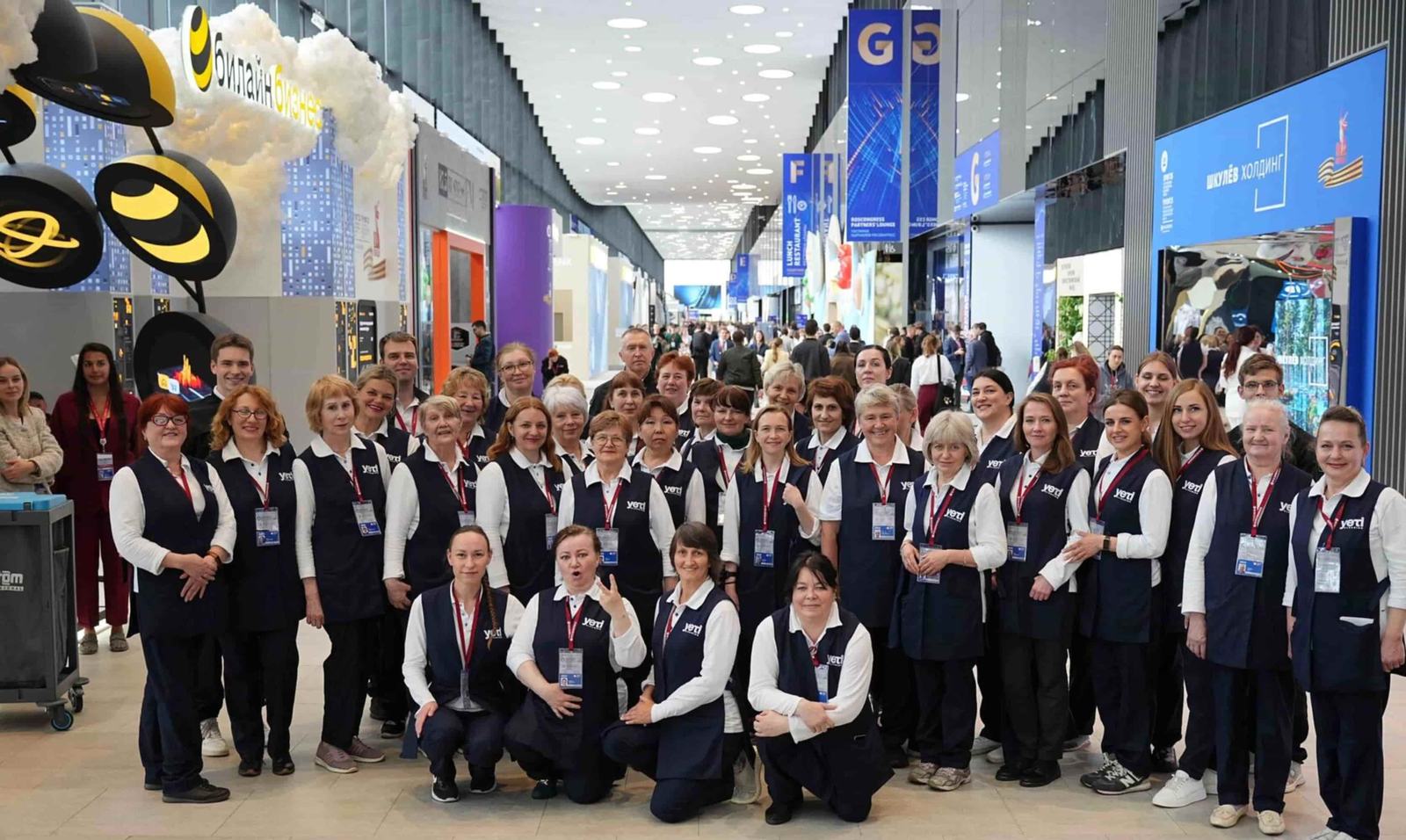 Команда уборщиков Yeti Cleaning в форме на выставочной площадке форума