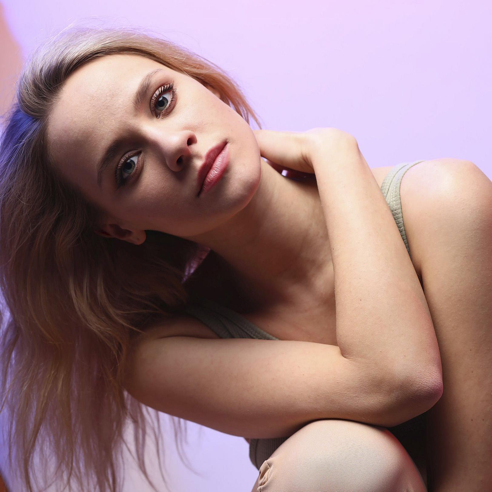 Диана Скокова позирует сидя рукой на плече