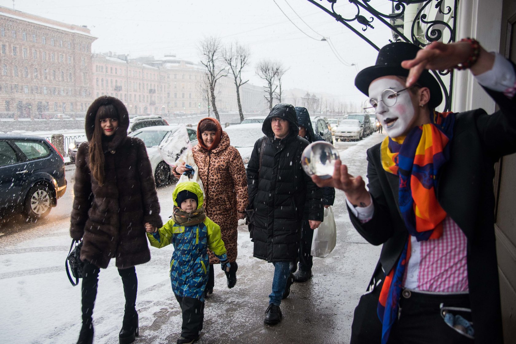 Мим с прозрачным шаром на городской улице.