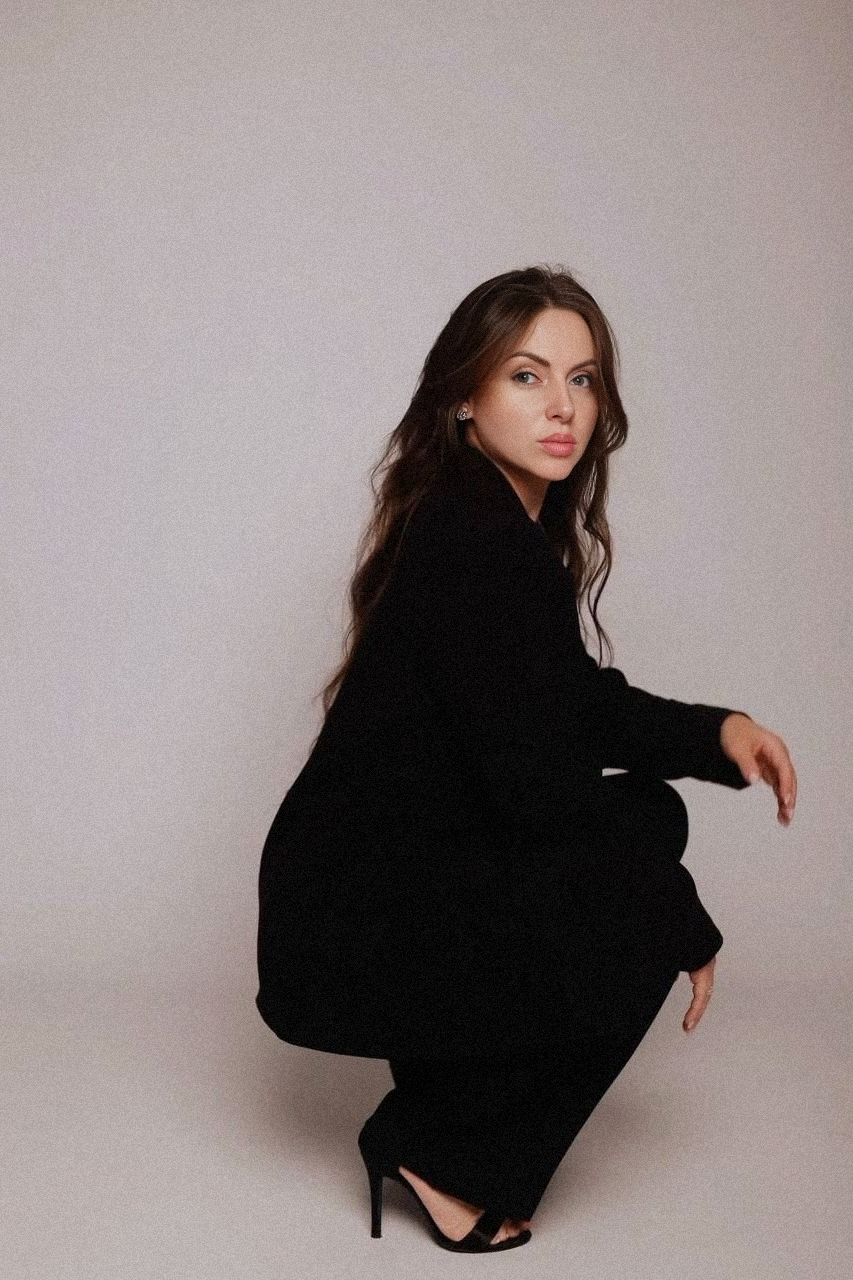 девушка сидит на корточках и смотрит в сторону