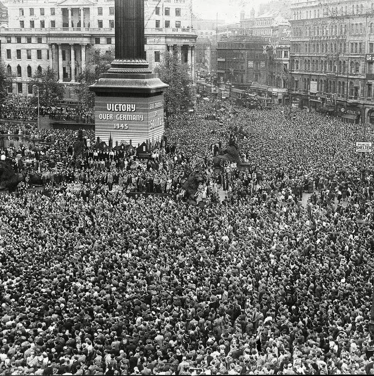 Большая толпа людей празднует День перемирия на Трафальгарской площади в Лондоне, 1918 год.