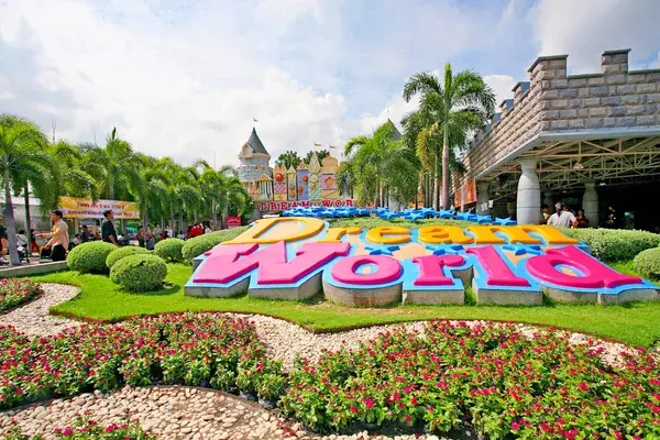 Объёмная цветная надпись Dream World на клумбе и замок Fantasy Land на входе