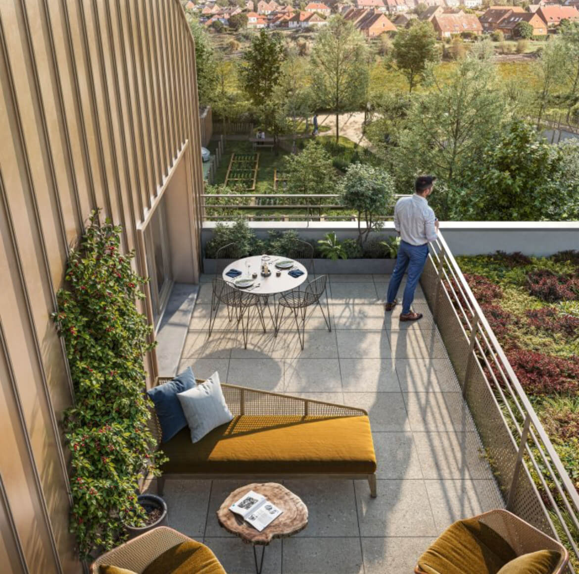 A man stands with a cup of coffee on the terrace of a new apartment, looking out toward a village with beautiful houses in the distance