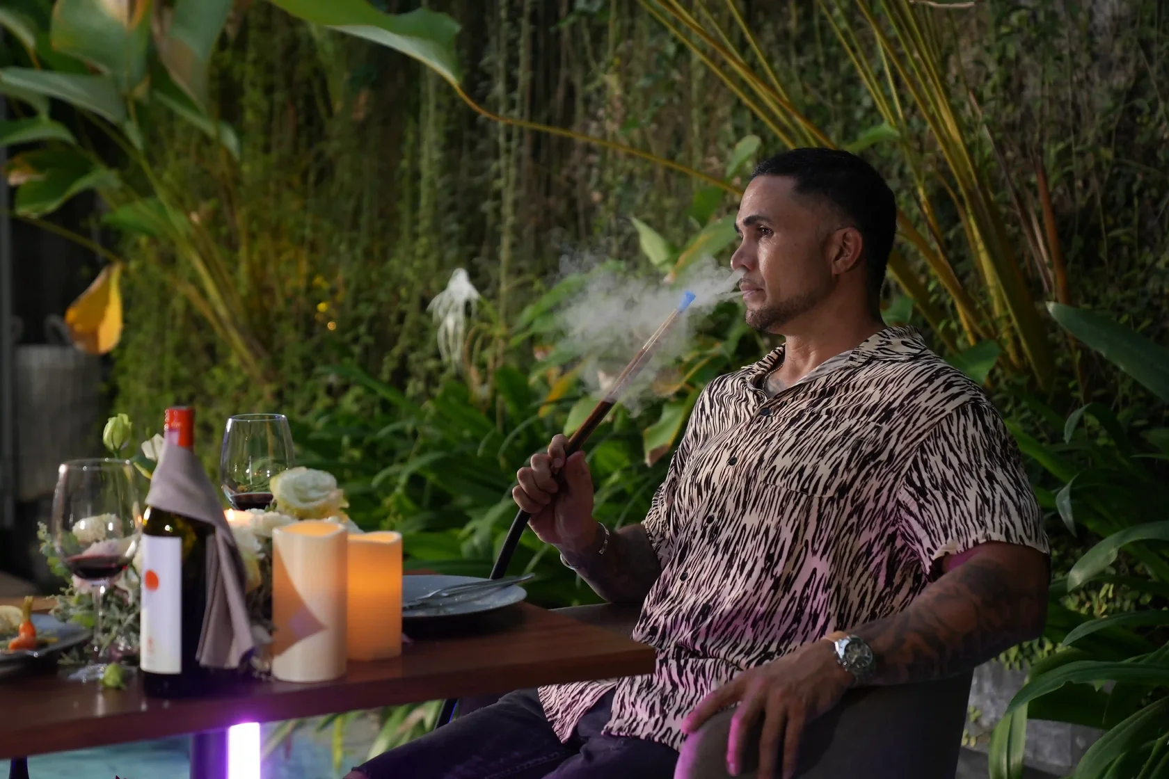 Man exhaling smoke while enjoying a relaxing shisha date at Eden Hookah Club Bali.