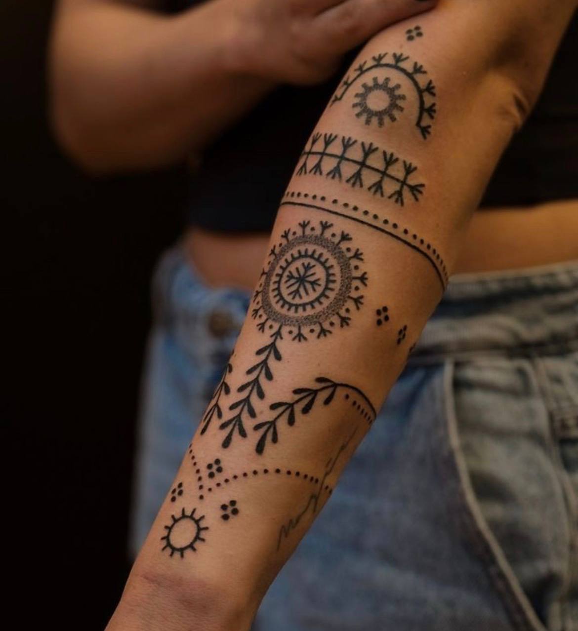 Татуировка с дугами, точками и ветвями в северной стилистике