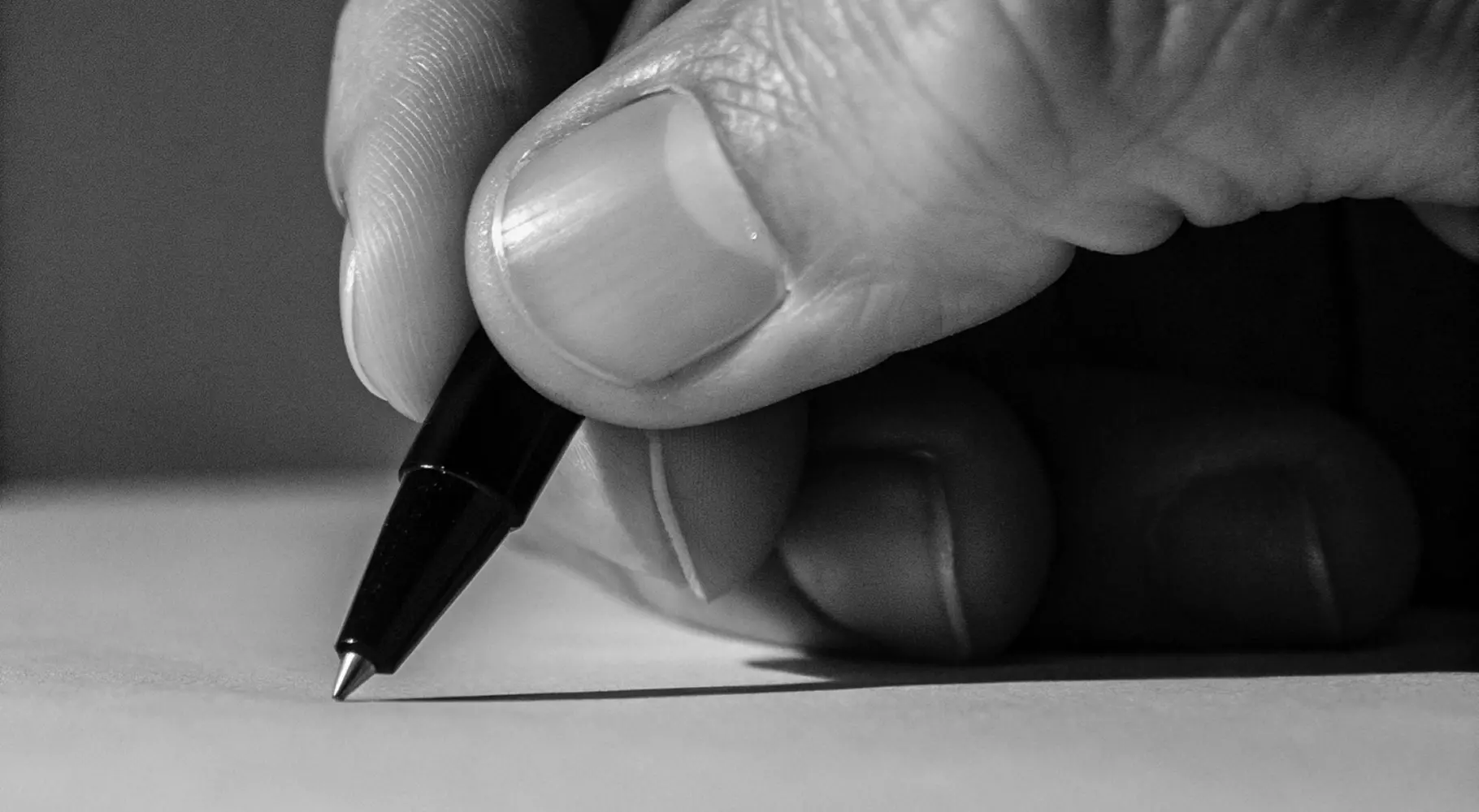 Рука держит ручку, символизируя написание текста