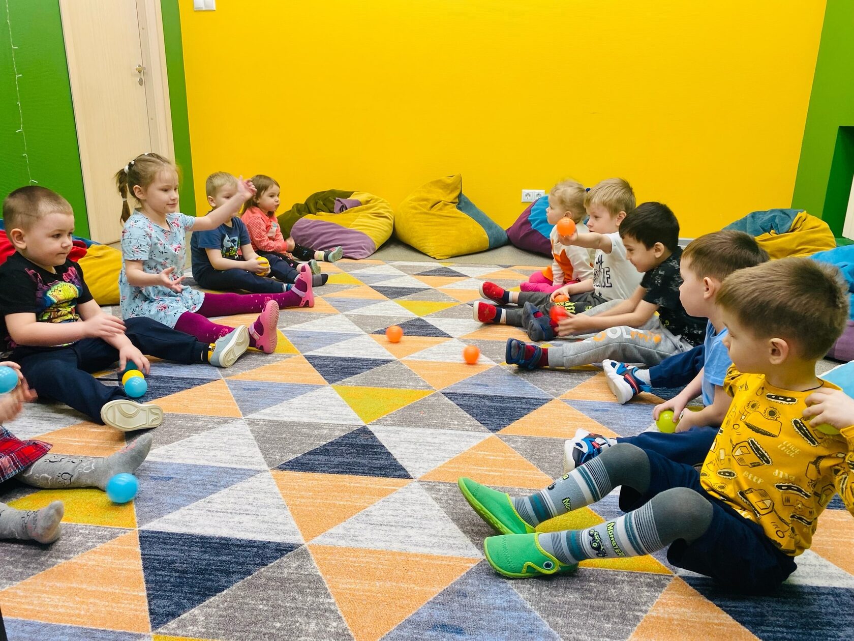 Дети в детском саду играю в шарики