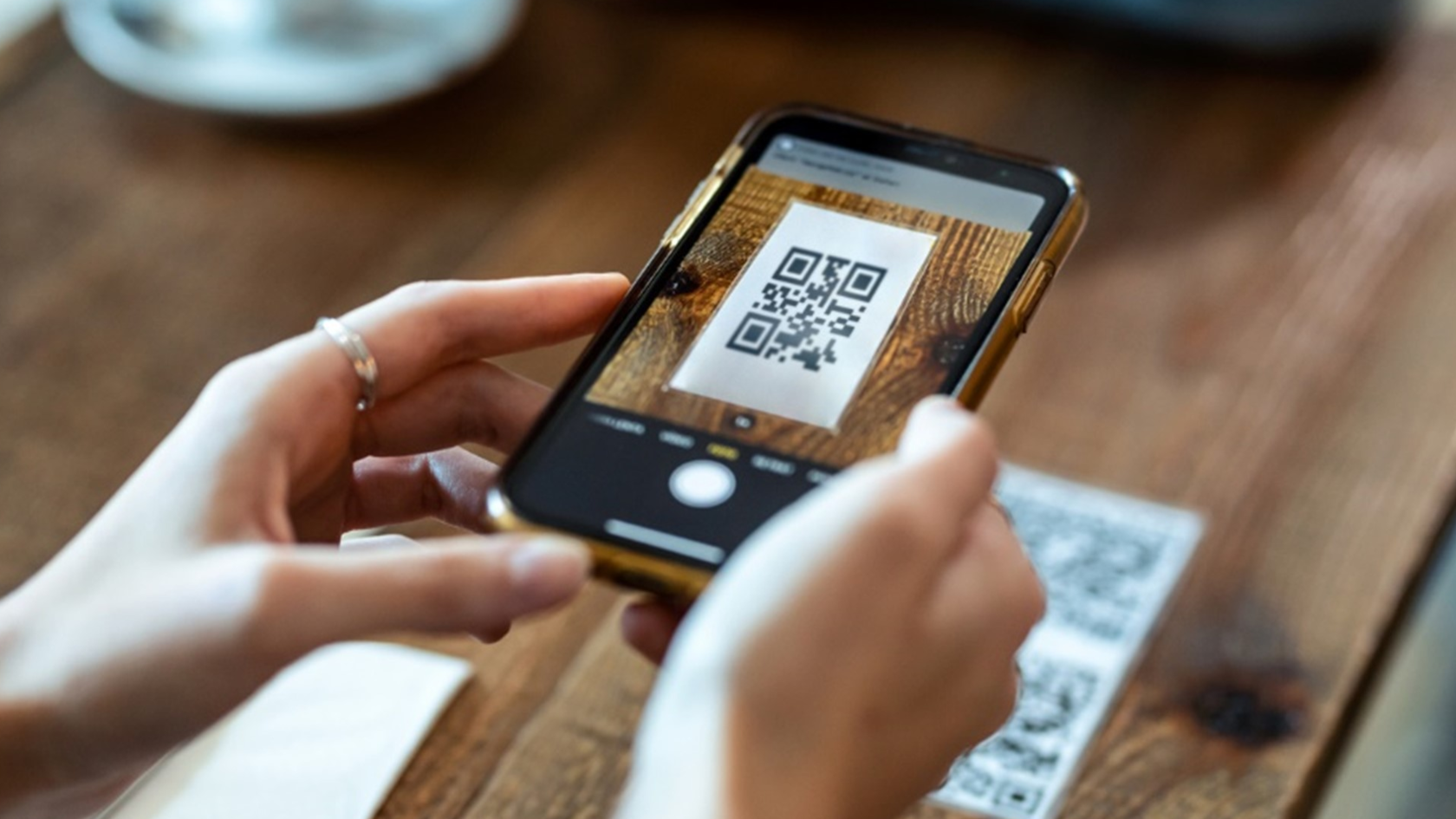 Клиент сканирует смартфоном QR-код, чтобы перейти в электронное меню ресторана