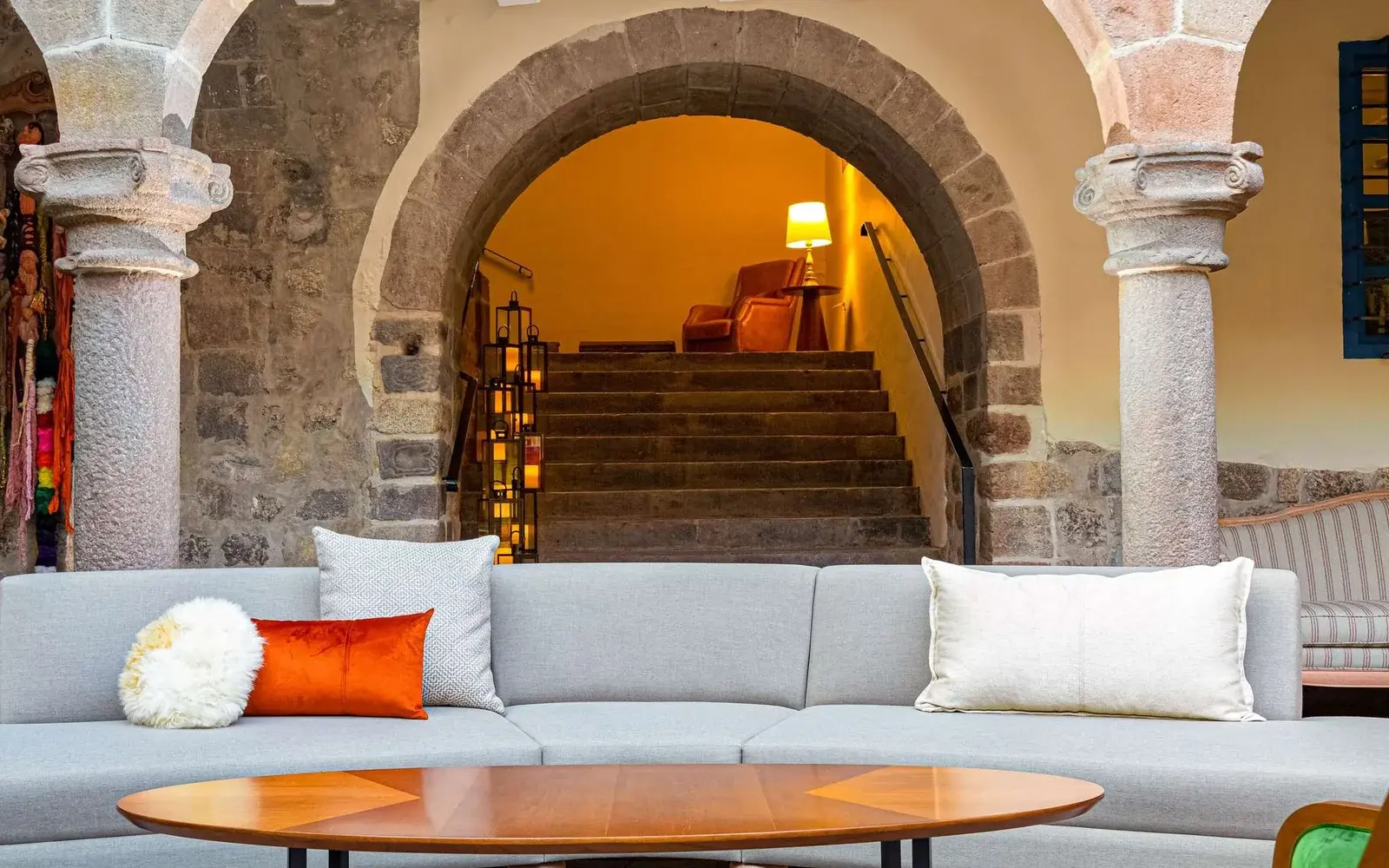 Лобби под каменной аркой с диваном и лестницей, Novotel Cusco