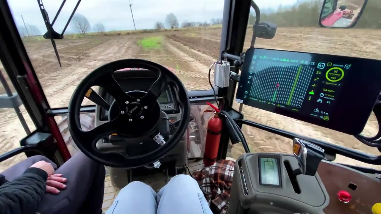 Механизатор в кабине трактора с автопилотом