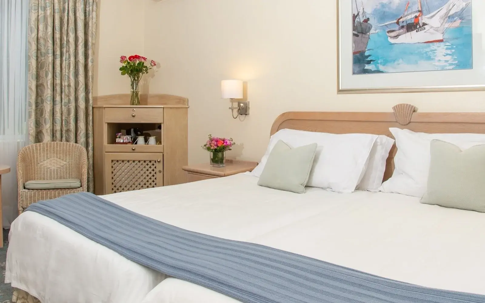 Номер со светлой кроватью, креслом и картиной над изголовьем, The Beach Hotel