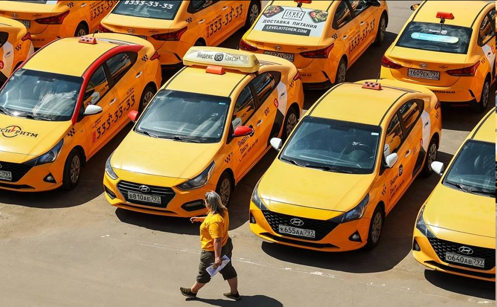 Все про такси: автомобили такси и Яндекс Go стоят на парковке в два ряда