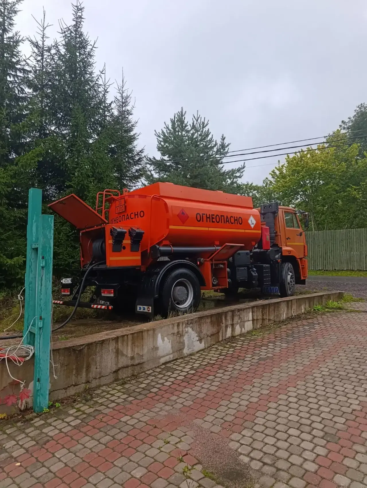 Бензовоз у частного дома во время доставки топлива в ёмкость для отопления