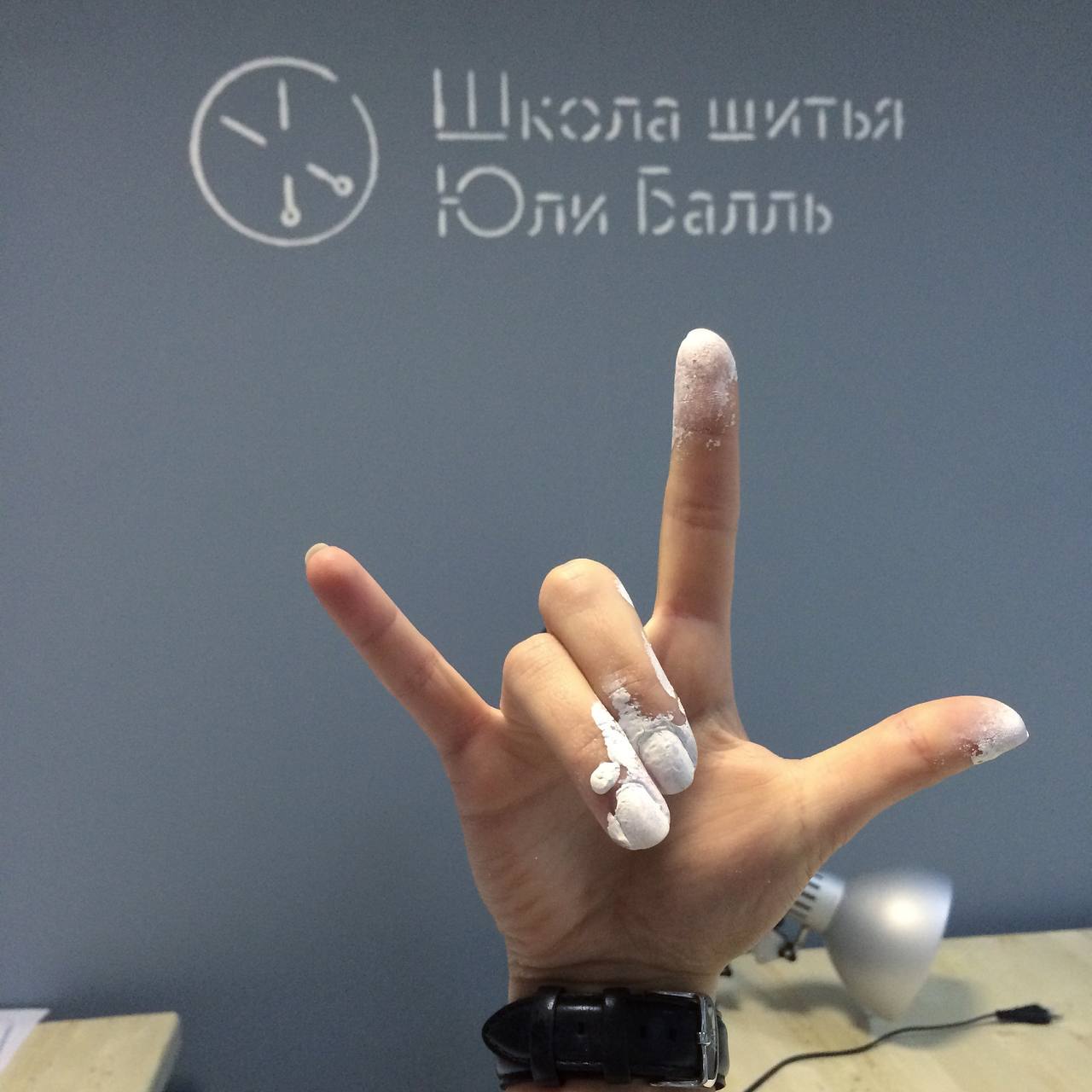Рука с мелом у стены школы