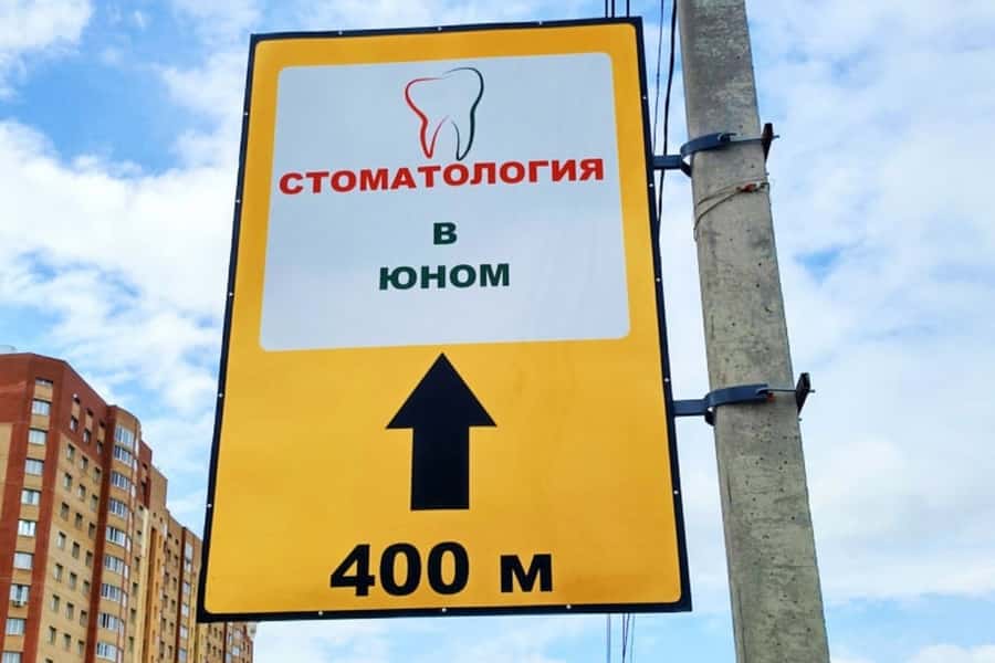 Рекламная табличка для стоматологии на столбе