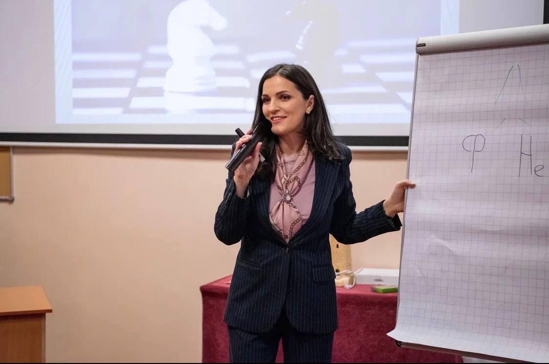 Юлия Салманова ведёт тренинг у флипчарта
