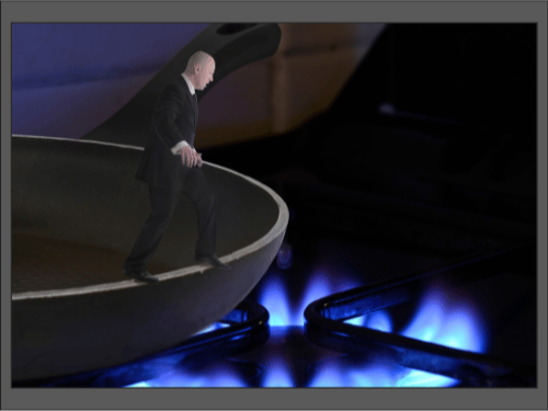 Мужчина в костюме стоит в сковороде над включённой газовой плитой с синим пламенем.