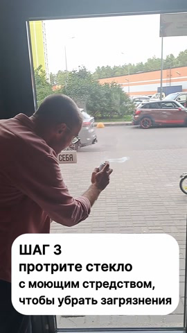 Сотрудник протирает стекло двери