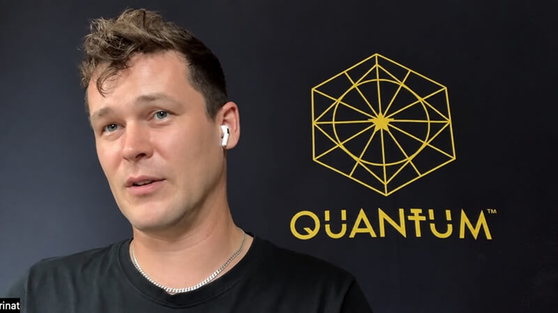 Rinat Mingazdinov speaking on camera in front of the QUANTUM backdrop — 620