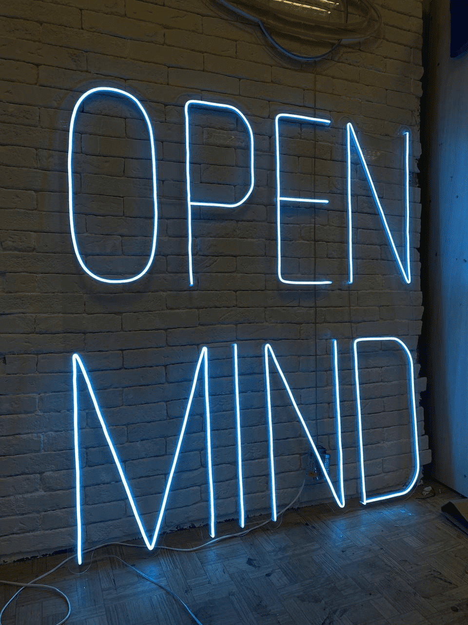 Вывеска OPEN MIND из гибкого неона голубого цвета на кирпичной стене