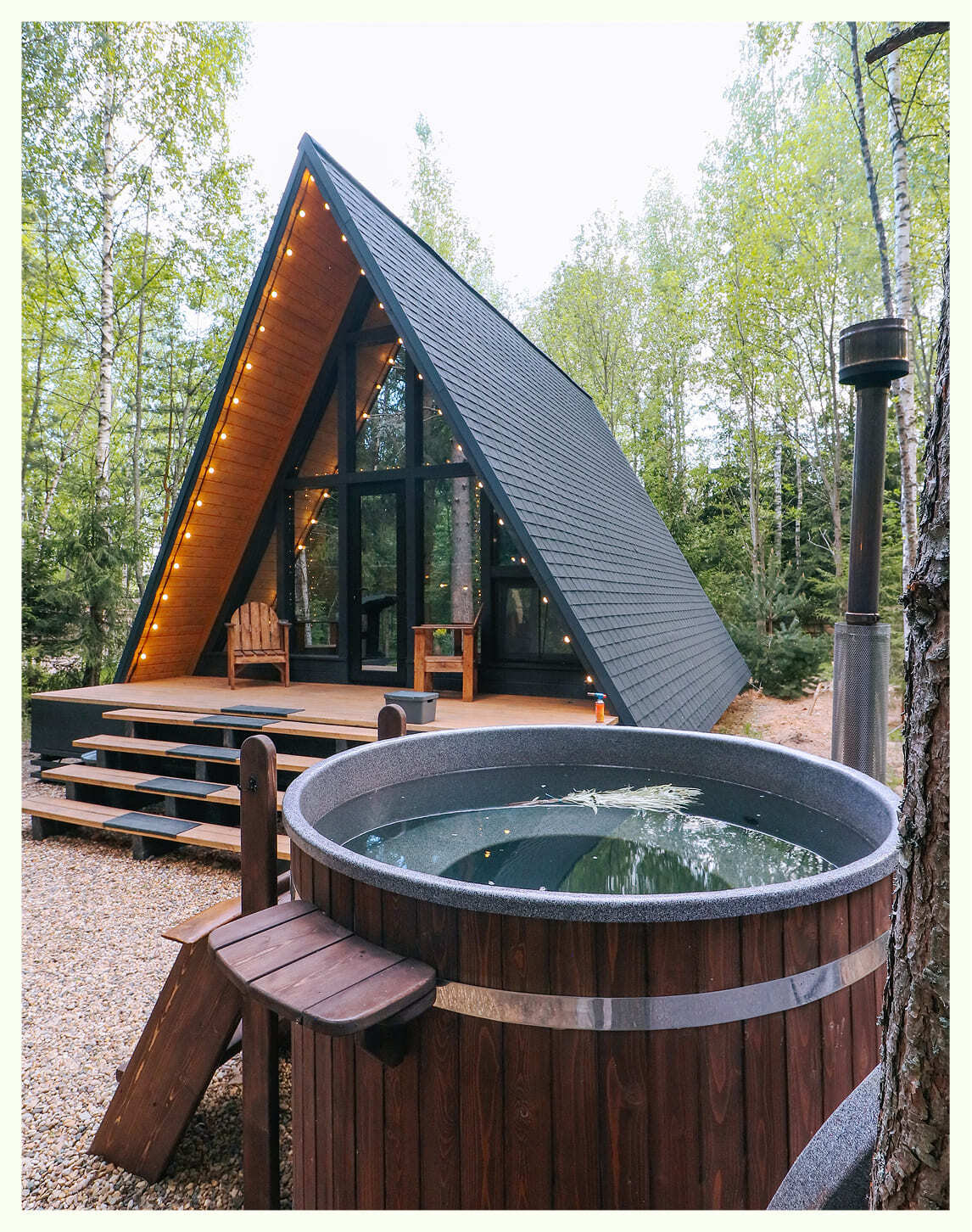 Деревянная купель фурако на террасе с видом на лес в глэмпинге Подмосковья