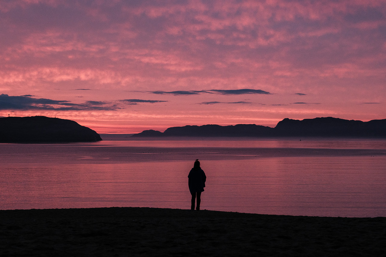 Девушка на пляже Териберки во время заката