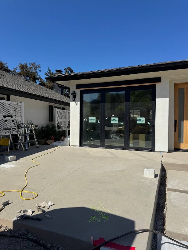 Uncovered concrete patio with prepared support bases before the pergola was installed.