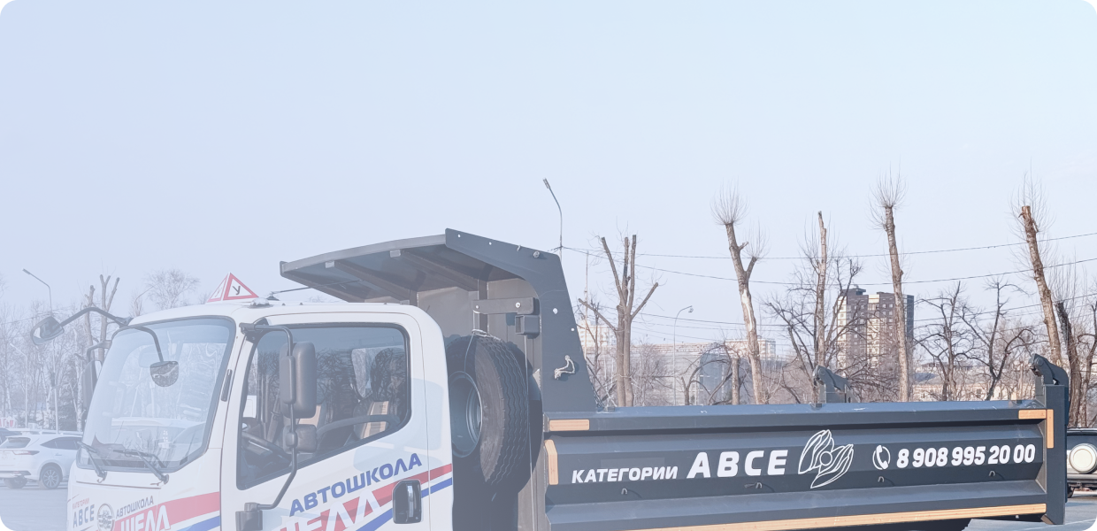 Черно-бронзовый мотоцикл стоит на стоянке у серого бетонного здания, вид сбоку