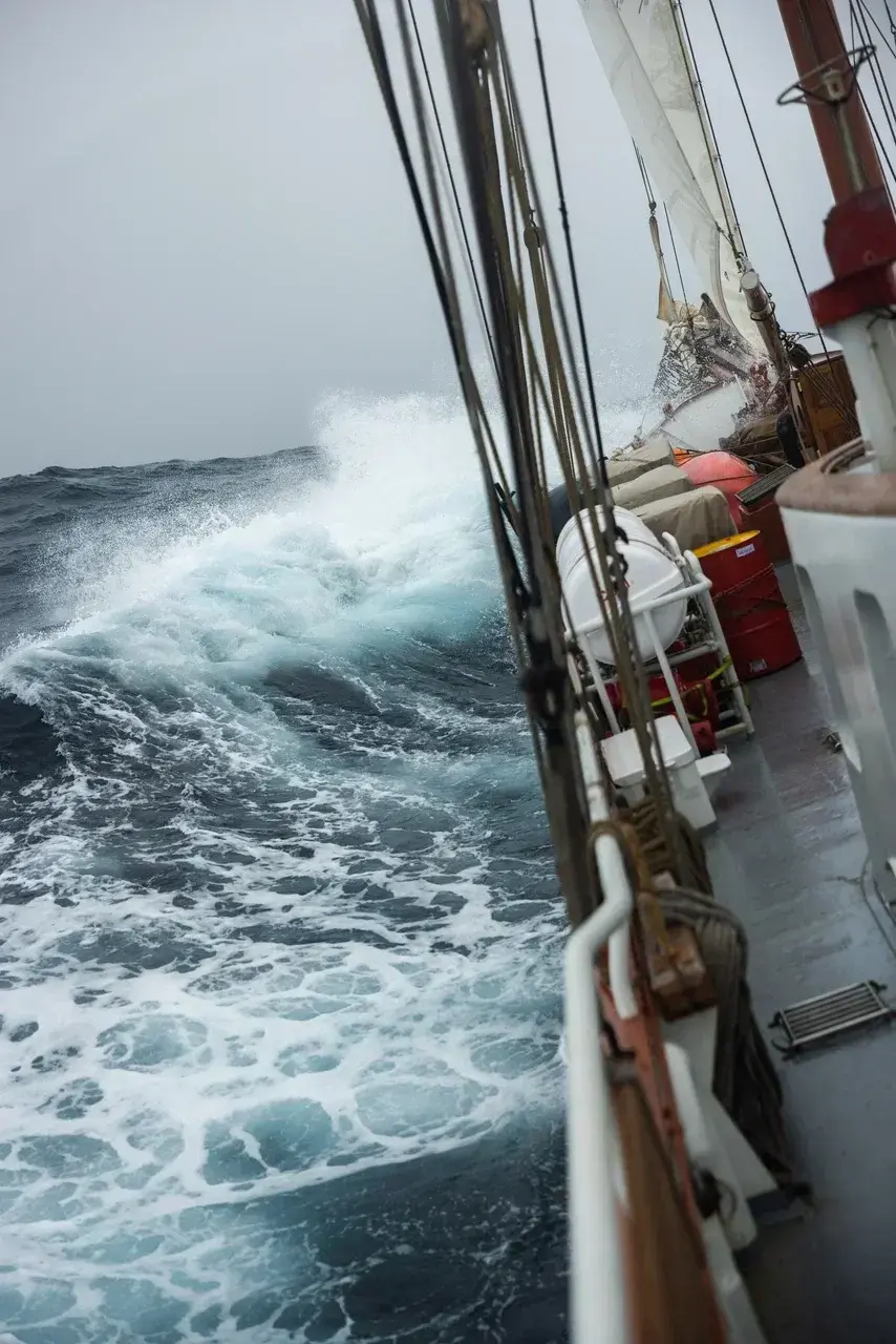 Powerful waves crash against the deck of a sailing yacht during a Drake Passage crossing. The dramatic Southern Ocean conditions showcase why the Drake is considered one of the worlds most legendary and challenging sea crossings on the way to Antarctica.