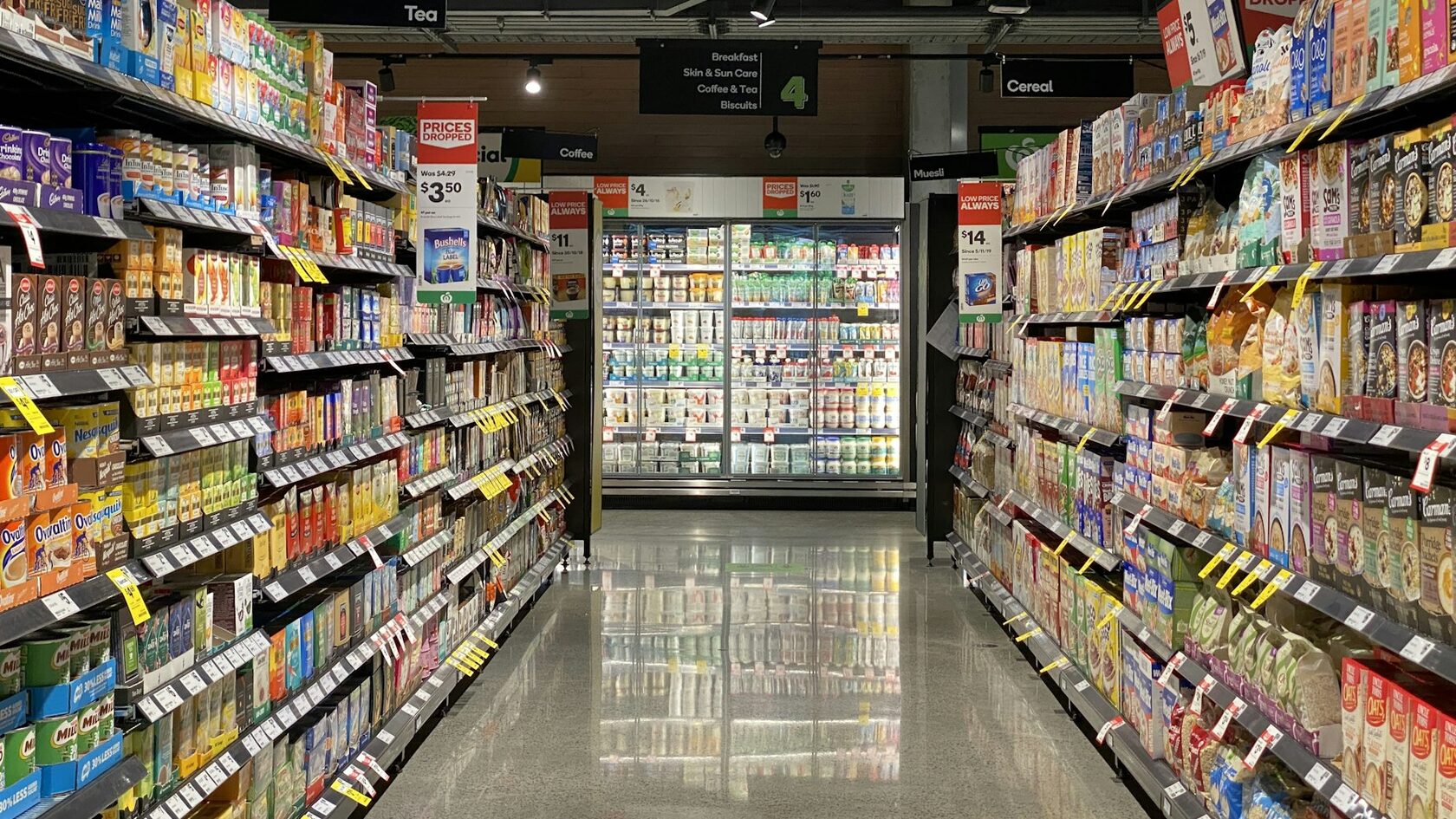 Прохід продуктового магазину зі стелажами