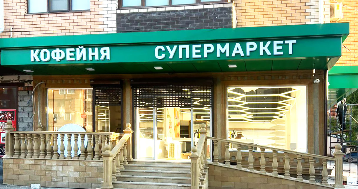 Объемные буквы из черного глянцевого акрила с алюминиевыми бортами и контражурной подсветкой на фоне серебристого композита. В светлое время - стильно и серьёзно. В темное время суток - яркий контур вокруг букв!