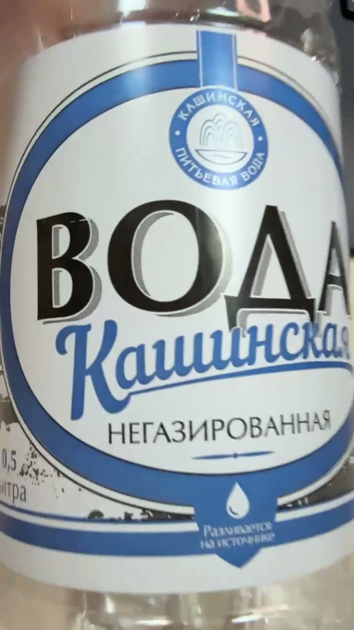Этикетка бутылки воды «Кашинская» издалека: у букв «ВОДА» видна ровная серая тень