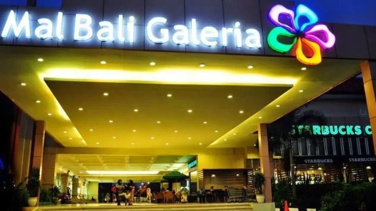 The brightly lit main entrance of Mal Bali Galeria at night, offering an affordable and highly strategic public cinema choice for those wondering where to watch a movie in Bali.
