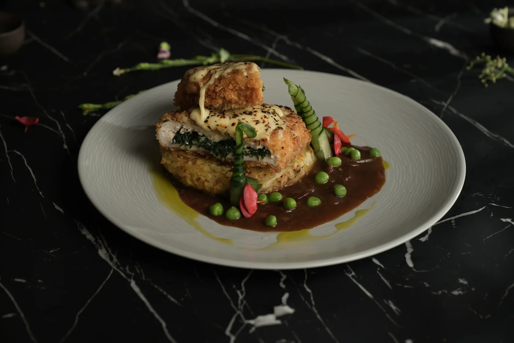 Stuffed Cheesy Chicken Dijhon with potato rosti, green peas, and Dijon sauce