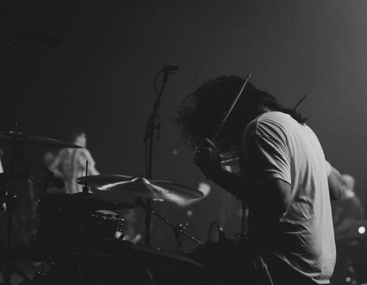 Черное-белое изображение мужчины, демонстрирующего игру на барабанах