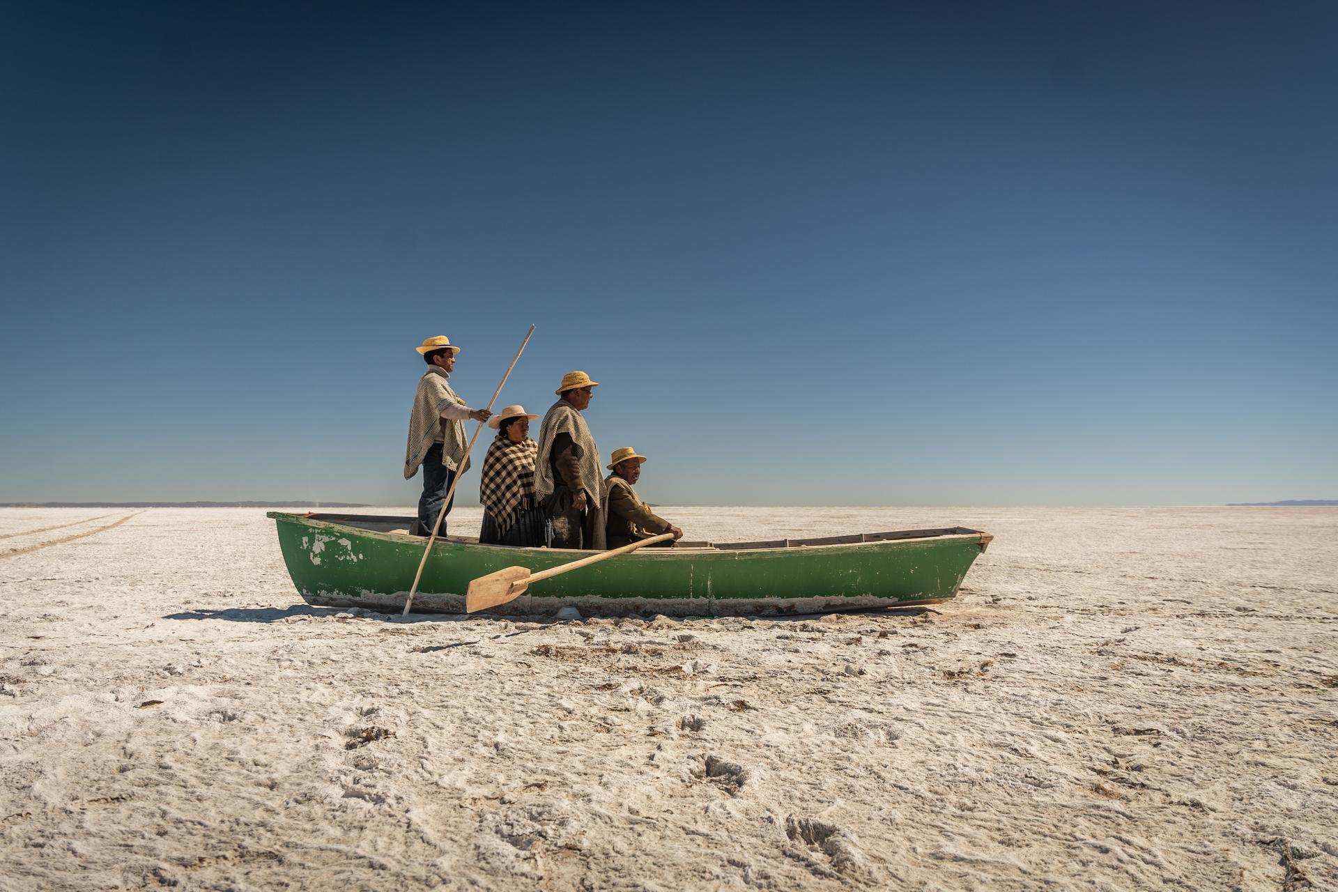 Bolivia | Gastón Zilberman. Members of the Qotzuñi community sit in a boat stranded on the salt flats where Lake Poopó once existed, following the lake’s disappearance due to climate change. 