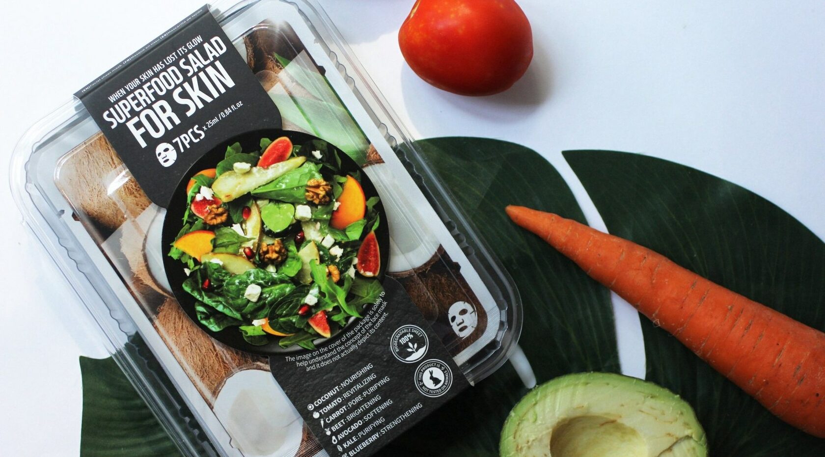 Набор масок Superfood salad for skin лежит рядом с морковью, авокадо и помидором