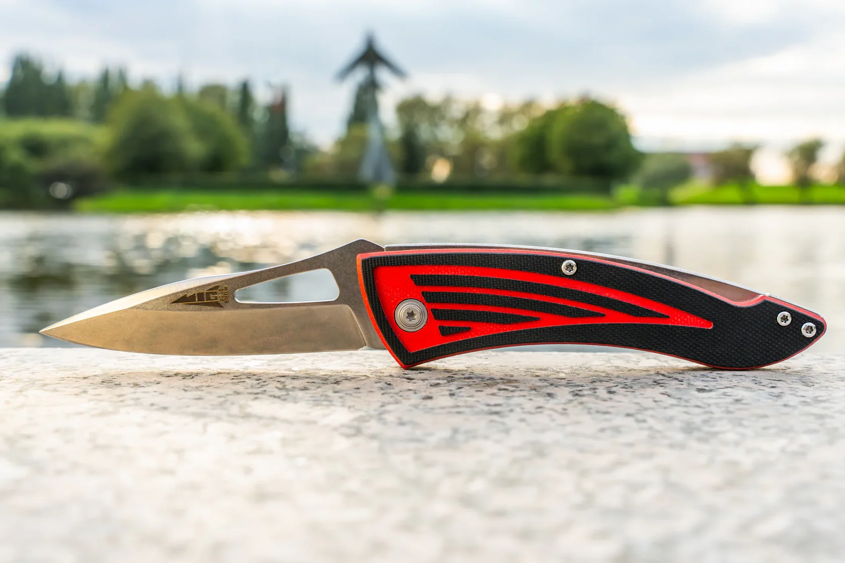 MiG folding knife in side profile with a lakeside background