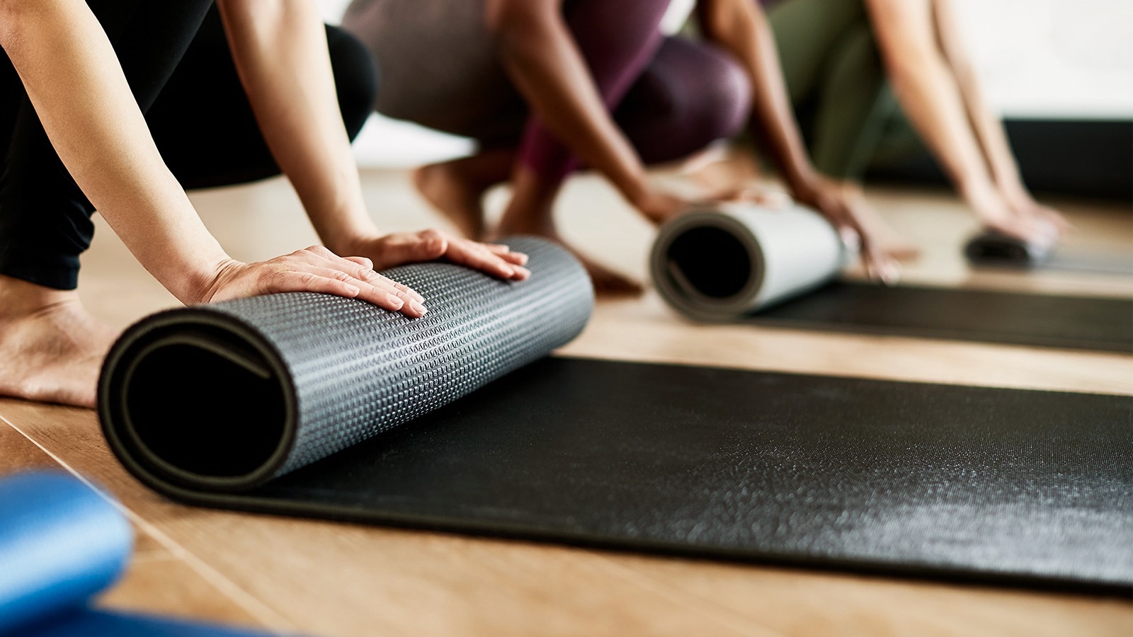 Женщины расстилают коврики перед практикой йоги